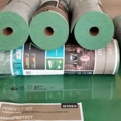 Rolki zielonego podkładu pod panele laminowane Wineo SoundPROTECT. Idealny materiał izolacyjny, zapewniający komfort i ochronę.