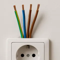 Cztery przewody elektryczne wychodzące z białego gniazdka. Zastanawiasz się, jaki kabel do gniazdek?