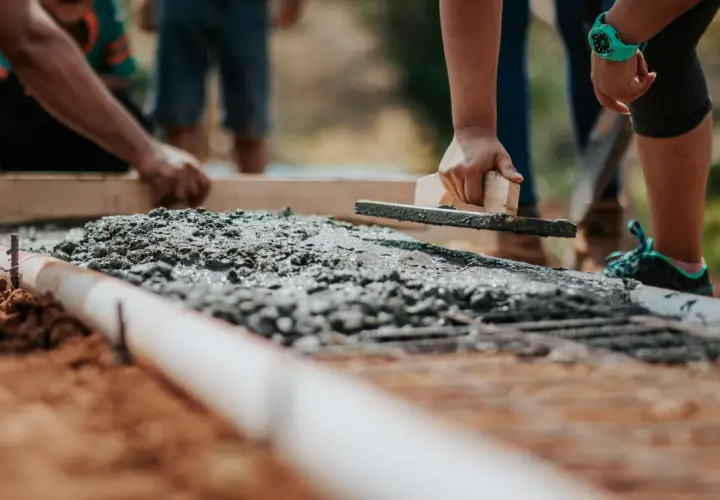 Pracownicy wygładzają świeży beton. Zastanawiasz się, ile kosztuje m3 betonu na budowie?