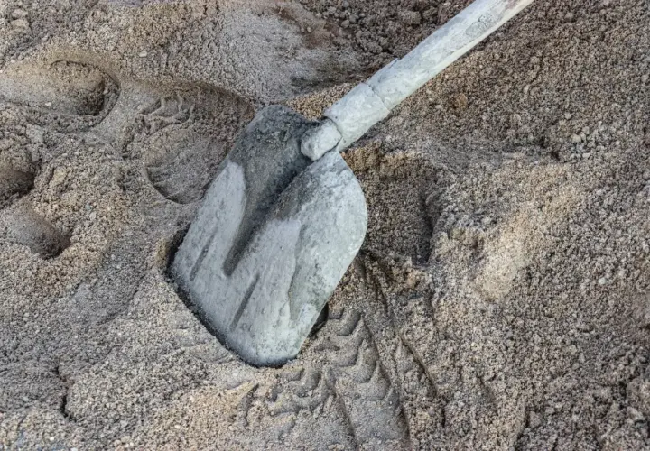 Łopata w piasku, ślady butów i opon. Zastanawiasz się, ile cementu na m3 betonu B20?