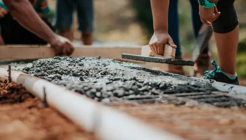 Pracownicy wygładzają świeży beton. Zastanawiasz się, ile kosztuje m3 betonu na budowie?