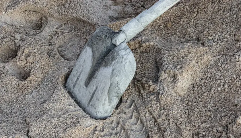 Łopata w piasku, ślady butów i opon. Zastanawiasz się, ile cementu na m3 betonu B20?