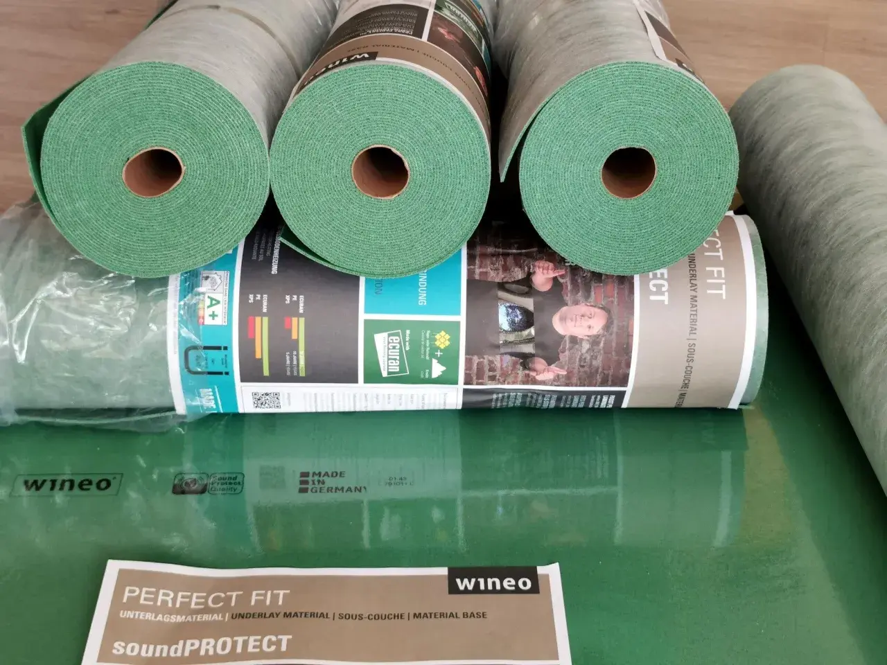 Rolki zielonego podkładu pod panele laminowane Wineo SoundPROTECT. Idealny materiał izolacyjny, zapewniający komfort i ochronę.