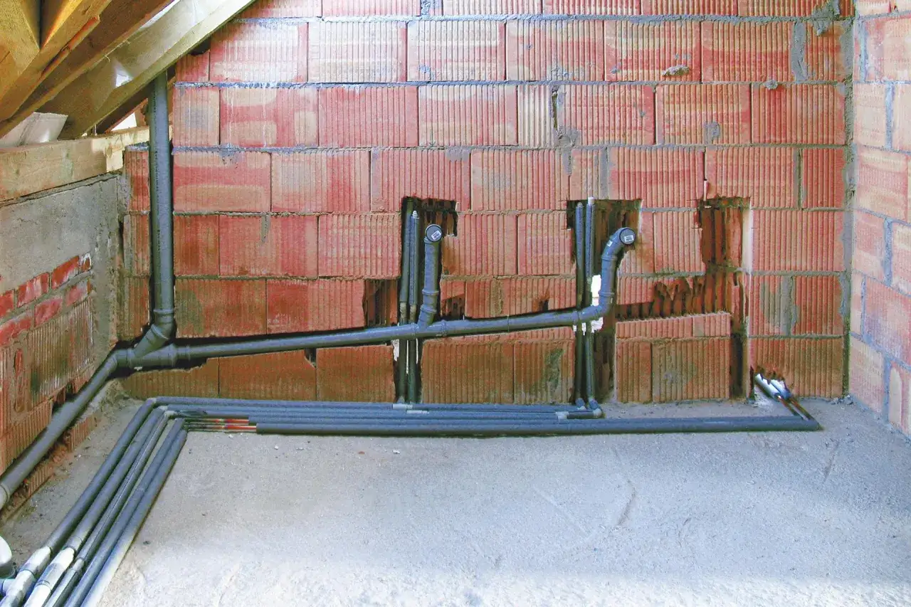 Instalacja kanalizacyjna z rurami 160 mm, ułożonymi z minimalnym spadkiem, w ścianie z pustaków ceramicznych.